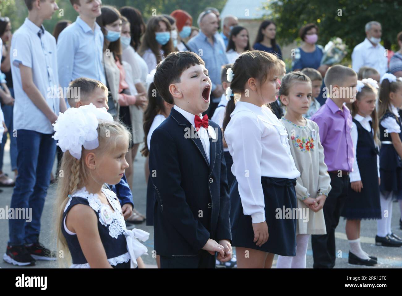 200902 -- KIEW, 2. September 2020 -- Ein Junge gähnt bei der Eröffnungszeremonie des neuen Schuljahres an einer Schule in der Oblast Kiew, Ukraine, 1. September 2020. Mehr als 4,2 Millionen Schüler haben ihr Studium in der Ukraine wieder aufgenommen, darunter 428.000 Erstklässler, da das Land den Beginn des neuen Schuljahres markiert. Kinder aus den 21 Städten und Bezirken in roten Quarantänezonen kehren nicht persönlich zur Schule zurück, sondern lernen aus der Ferne, bis sich die epidemiologische Situation ändert. Foto von /Xinhua UKRAINE-KIEW-SCHULEN-NEUES SCHULJAHR SergeyxStarostenko PUBLICATIONxNOTxINxCHN Stockfoto