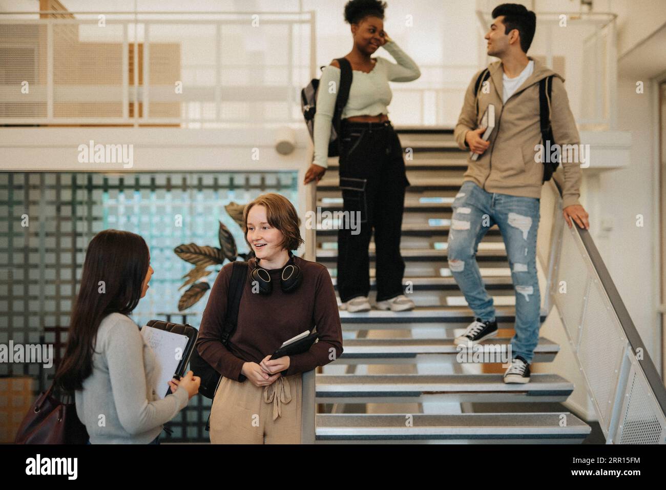 Multirassische Studierende mit Rucksäcken, die an der Universität reden Stockfoto