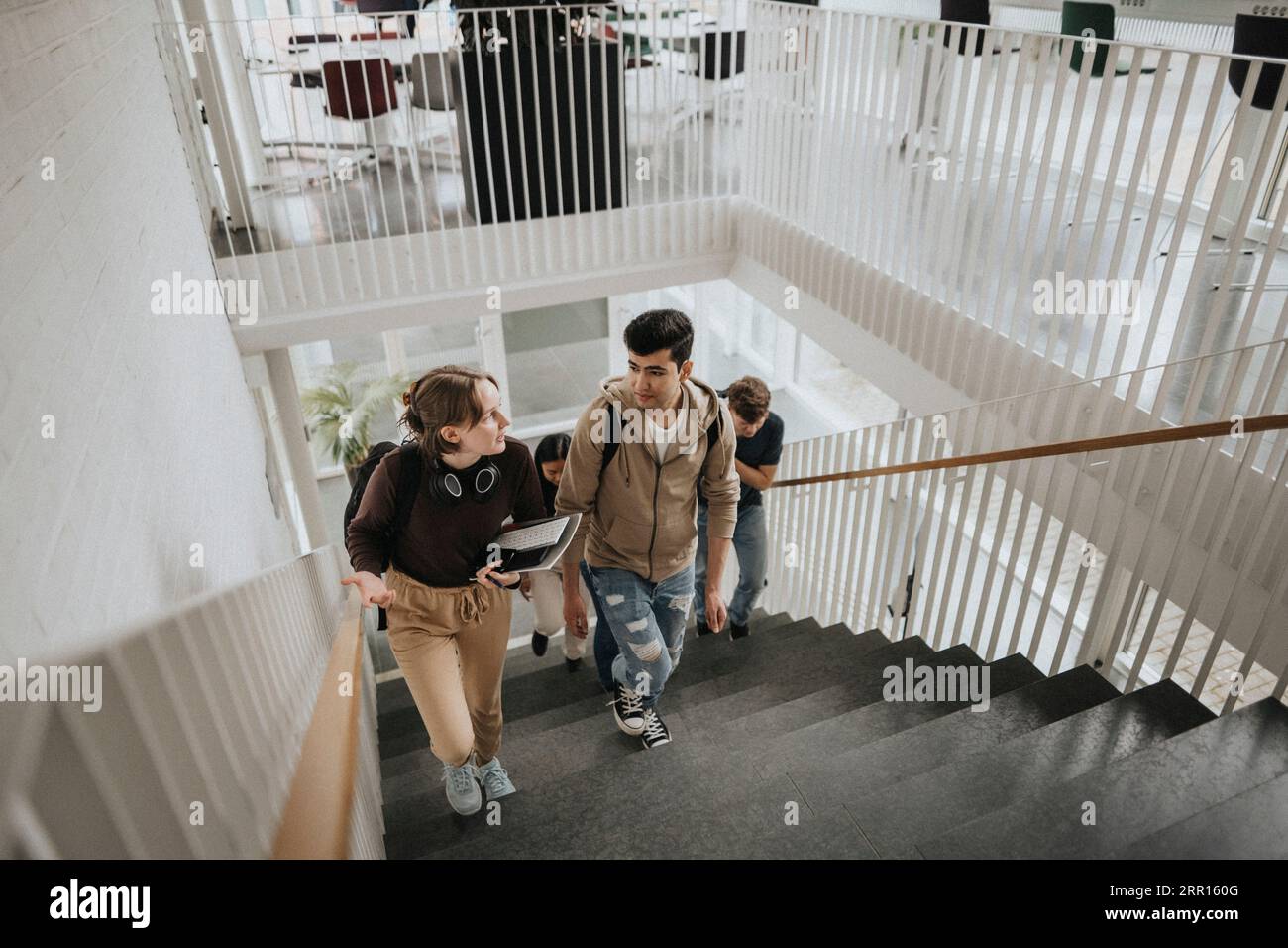 Blick auf Studenten, die auf Stufen in der Universität sprechen Stockfoto