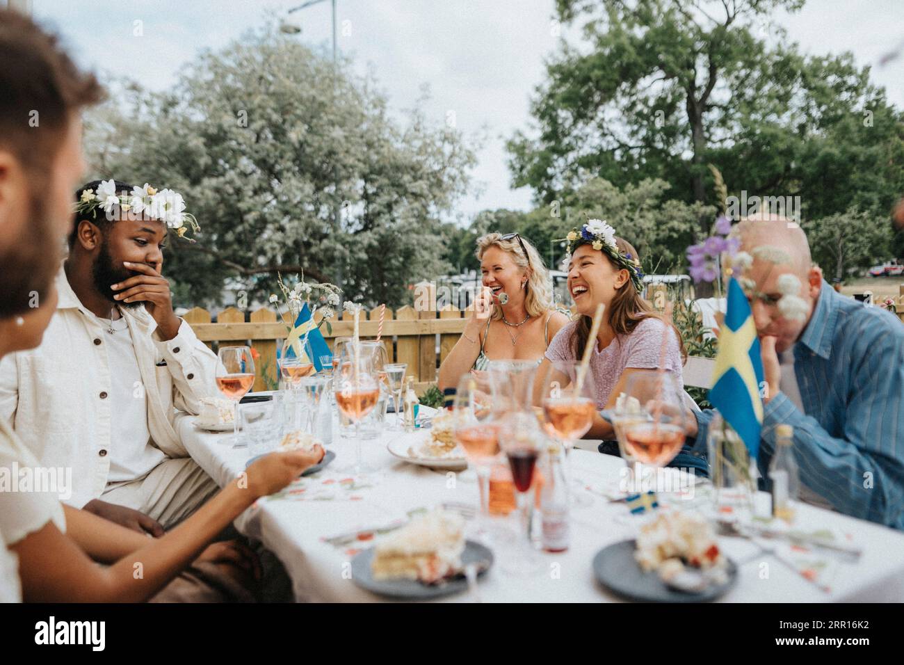 Fröhliche, multirassische Freunde feiern während einer Dinnerparty im Café Stockfoto