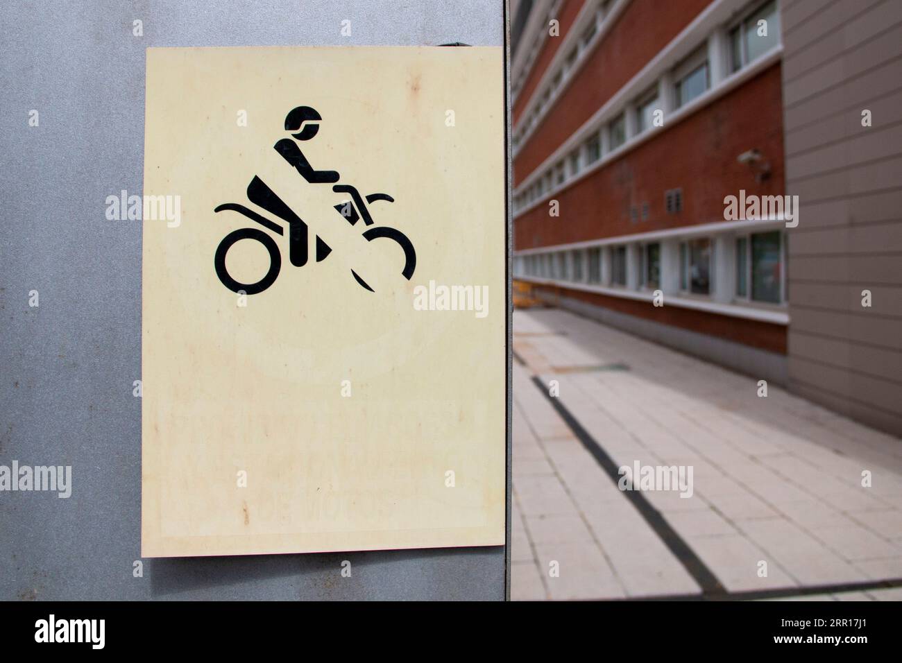 Auf der einen Seite gibt es kein Verkehrszeichen für Motorräder auf einem flachen Hintergrund und auf der anderen Seite keinen Korridor, der ihm Tiefe verleiht Stockfoto