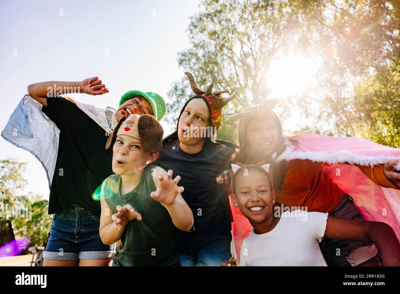 Glückliche Kinder machen Gesicht und Gesten, während sie im Sommercamp spielen Stockfoto