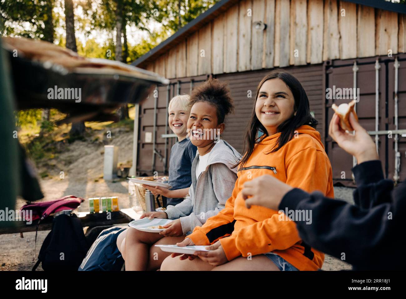 Glückliche Kinder genießen beim Essen im Sommercamp Stockfoto