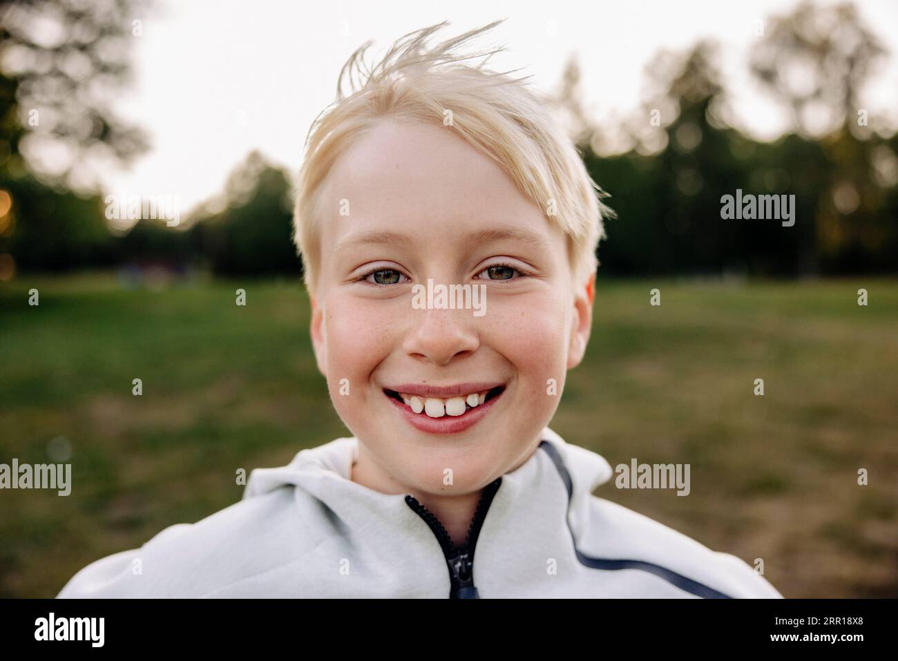 Porträt eines lächelnden blonden Jungen auf dem Spielplatz Stockfoto