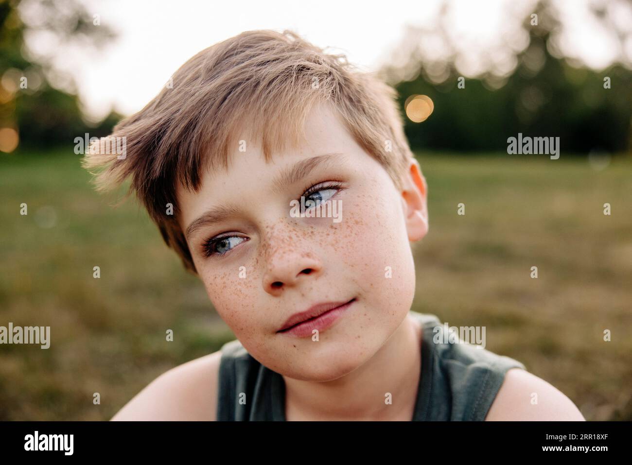 Junge mit Freckles-Tag träumt auf dem Spielplatz Stockfoto