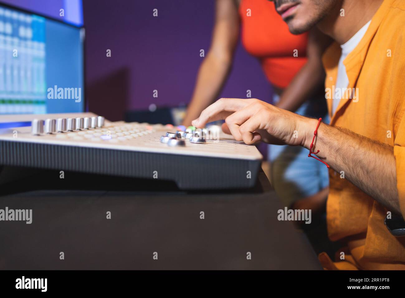 Ein unbekannter männlicher Tontechniker und eine afroamerikanische Sängerin, die Hit-Songs kreierten, während sie Mixboard und Computersoftware in Musik verwendeten Stockfoto
