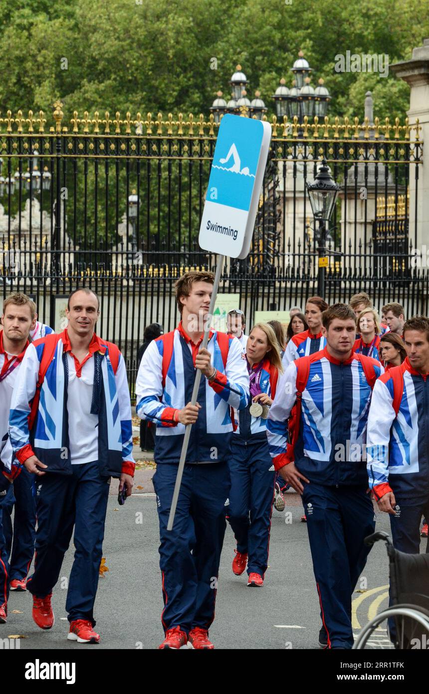 Schwimmer-Gruppe von Team GB Olympianern verlässt Buckingham Palace nach der Siegesparade. Olympische Spiele 2012 In London. Schwimm-Schild Stockfoto