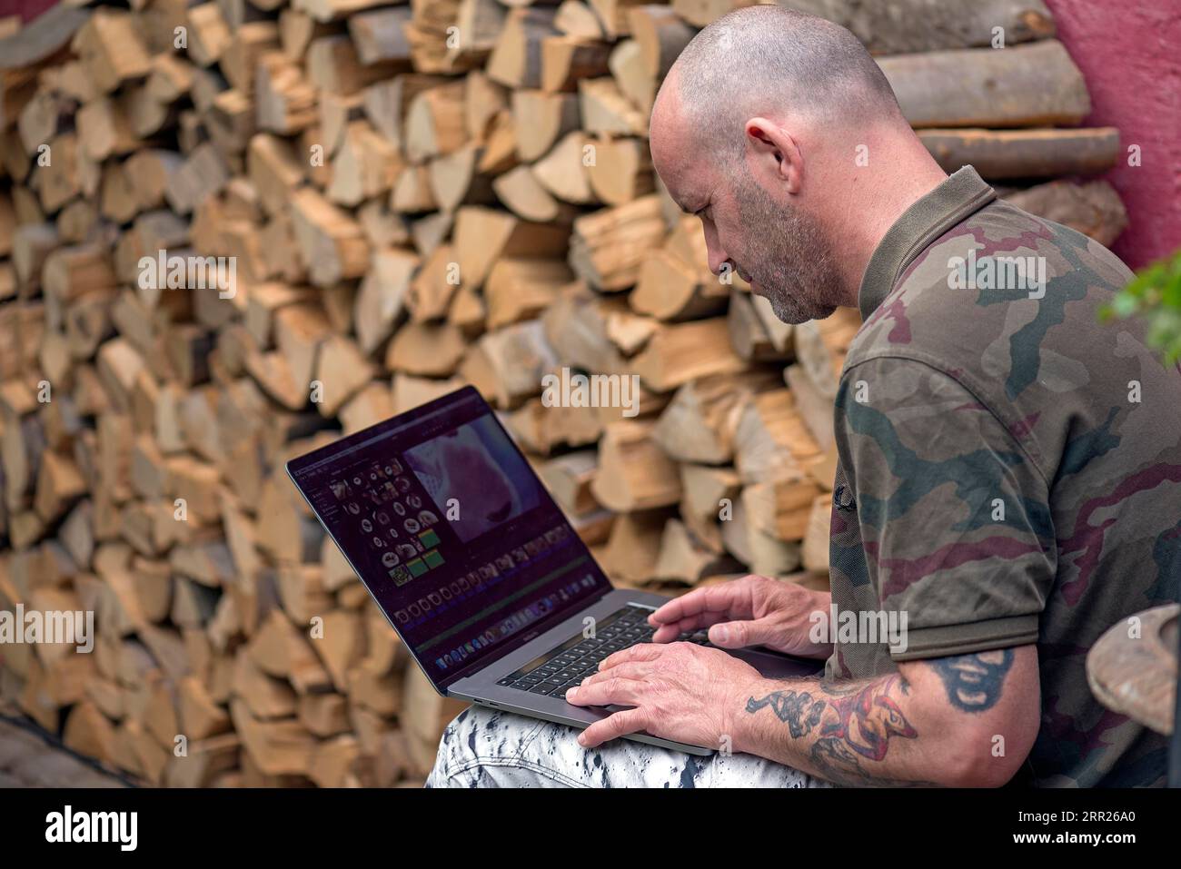 Junger Mann mit Laptop, Home Office im Garten, Baden-Württemberg, Deutschland Stockfoto