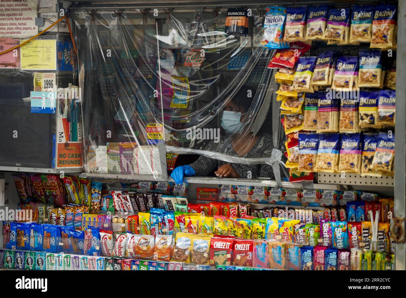 201008 -- NEW YORK, 8. Oktober 2020 -- Eine Verkäuferin wartet am 8. Oktober 2020 auf Kunden hinter einer Kunststoffabdeckung an ihrem Stand im Rego Park of Queens, einem COVID-19-Hotspot in New York, USA. Die jüngste Coronavirus-Positivitätsrate in den 20 Hotspots-Postleitzahlen in Queens, Brooklyn, Orange und Rockland County im Bundesstaat New York betrug 5,8 Prozent, mehr als das Fünffache der landesweiten Positivitätsrate ohne diese Postleitzahlen, die bei 1,01 Prozent lagen, twitterte Gouverneur Andrew Cuomo am Donnerstag. Stilllegungen nicht unbedingt notwendiger Unternehmen, Schulen und gesellschaftlicher Zusammenkünfte in diesen Krisengebieten haben g Stockfoto