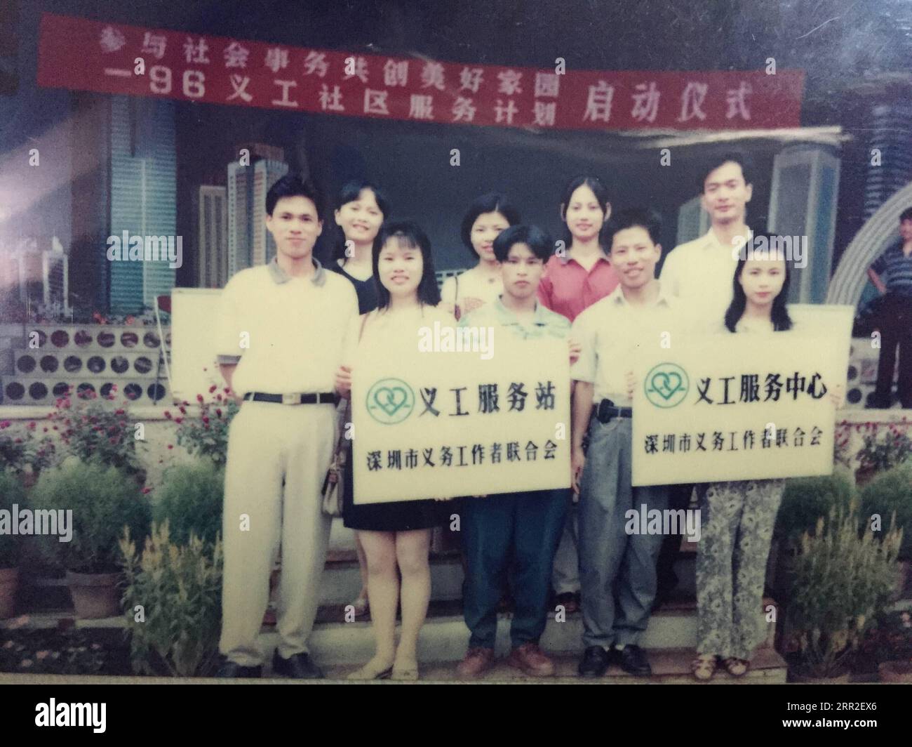 201010 -- SHENZHEN, 10. Oktober 2020 -- Xiong Yonglan 2. L, posiert für ein Foto, während sie die Gedenktafel des ersten Freiwilligendienstzentrums der Gemeinschaft des Bezirks Bao an in Shenzhen, Provinz Guangdong, am 24. August 1996 hält. Xiong Yonglan, die jetzt Managerin im Jugendpalast des Bao an Bezirks in Shenzhen ist, strebt seit ihrem Schritt in die Stadt nach einem besseren Leben in der Stadt. Im Jahr 1992 kam der 18-jährige Xiong Yonglan in die Niederlassung von Mabuchi Motor in Shenzhen und arbeitete an der Montagelinie. Bald, mit ihrer herausragenden Leistung bei der Arbeit, wurde Xiong zu einem Stockfoto