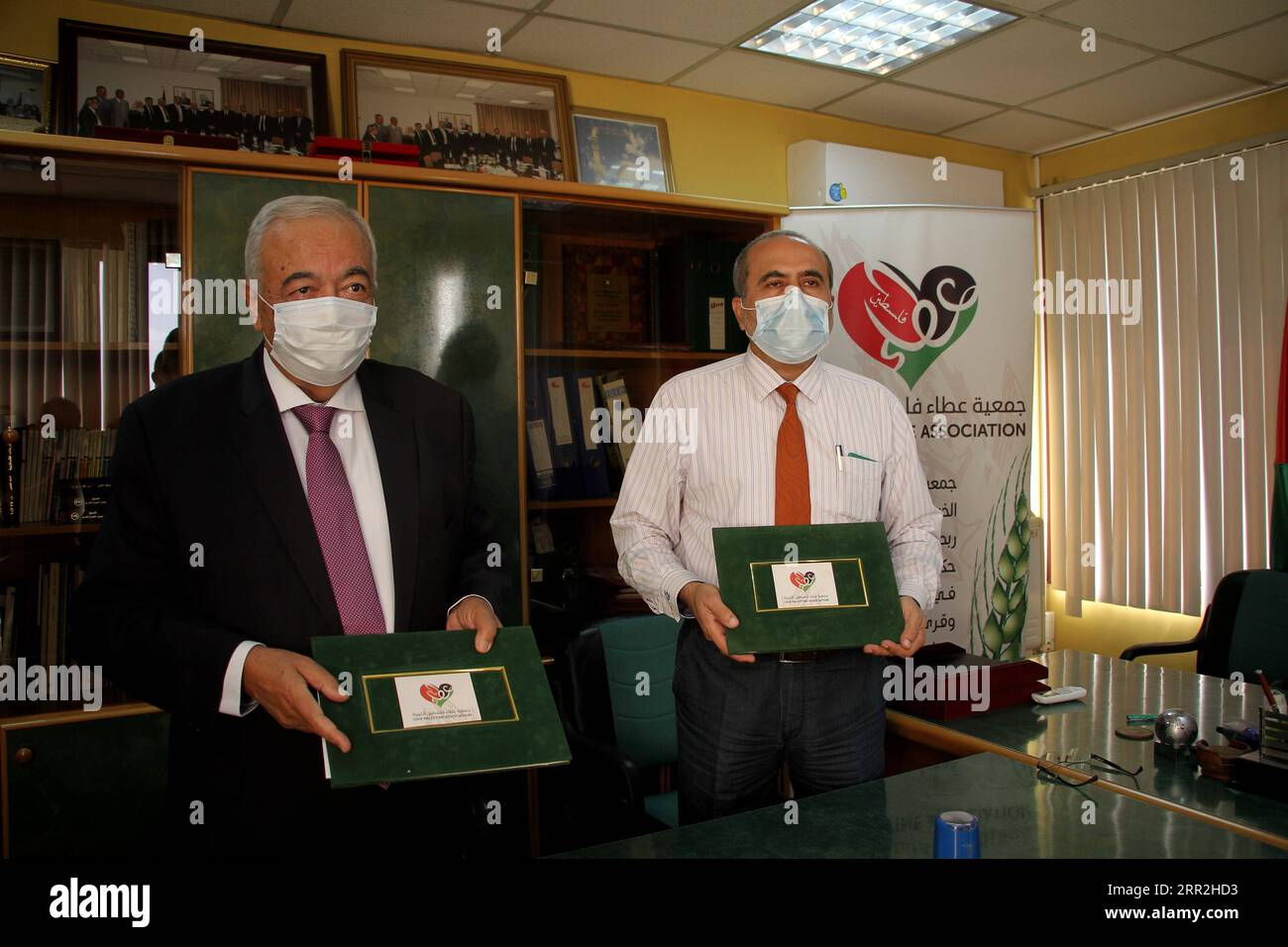 201012 -- GAZA, 12. Oktober 2020 -- Abdul Latif al-Haj R, Direktor für Krankenhausangelegenheiten im Gesundheitsministerium von Gaza, und Maamoun Abu Shahla, Vorsitzender der Wohltätigkeitsorganisation Give Palestine Association, zeigen das Abkommen in Gaza-Stadt am 12. Oktober 2020. Eine palästinensische Wohltätigkeitsorganisation unterzeichnete am Montag einen Vertrag mit dem Gesundheitsministerium von Gaza, um aus China finanzierte Solarenergieanlagen für ein Kinderkrankenhaus in Gaza-Stadt zu liefern und zu installieren. Foto von /Xinhua TO GO WITH Gaza installiert China-finanzierte Solarenergiekapseln für Kinderkrankenhäuser unter schweren Stromknappheit MIDEAST-GAZA STADT-CHINA-FINANZIERTE SOLARENERGIEKAPSELN Stockfoto