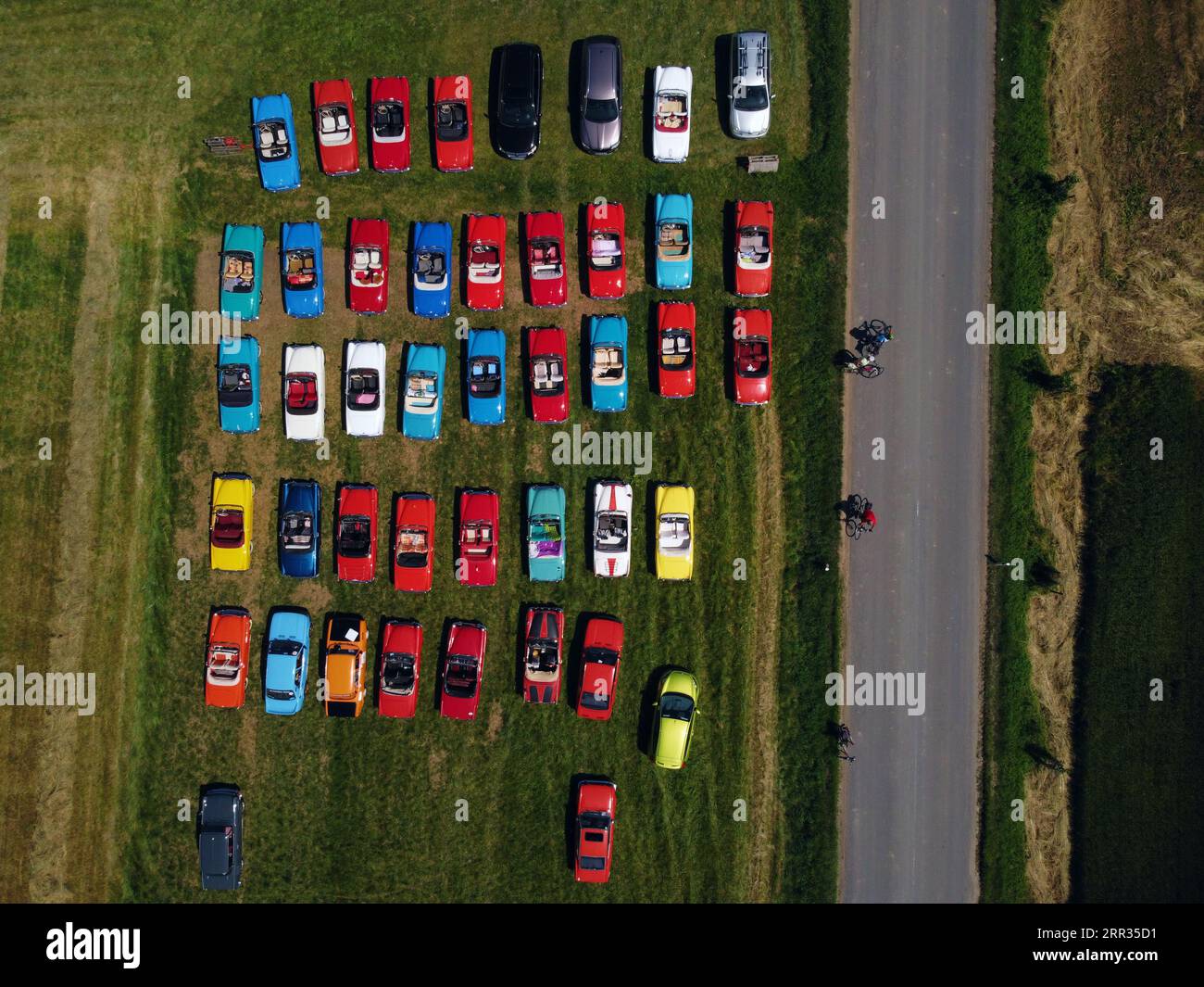 Eine Reihe von Fahrzeugen, die auf einem Parkplatz geparkt sind, um Gleichmäßigkeit und Konsistenz zu veranschaulichen Stockfoto