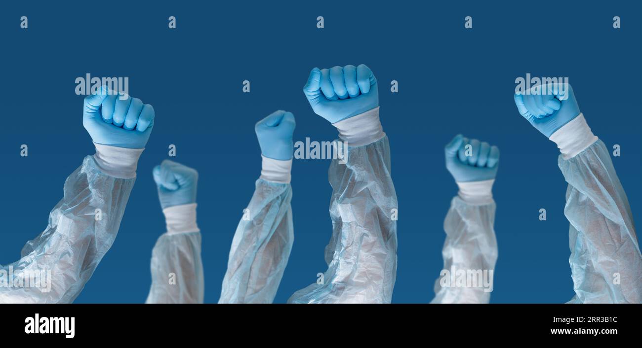 Porträt von medizinischem Personal, das Gesichtsmasken mit den Händen nach oben trägt und ein Schild hält, auf dem steht „Gesundheitspersonal“. Pandemie- und Gesundheitskrisenkonzept. Stockfoto