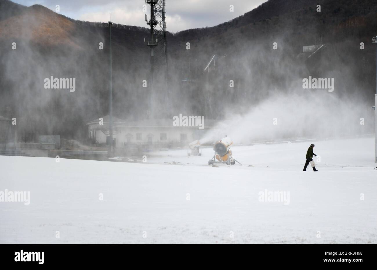 201103 -- CHANGCHUN, 3. Nov. 2020 -- Ein Mitarbeiter geht zu Fuß, während auf dem Beidahu-Skigebiet in der Stadt Jilin, Provinz Jilin im Nordosten Chinas, am 3. Nov. 2020 Schneeerzeugungsmaschinen arbeiten. Die Skigebiete in der Provinz Jilin bereiten sich auf die Skisaison vor, da die Temperaturen in diesen Tagen sinken. CHINA-JILIN-SKI-FELDER-KUNSTSCHNEEERZEUGUNG CN YANXLINYUN PUBLICATIONXNOTXINXCHN Stockfoto