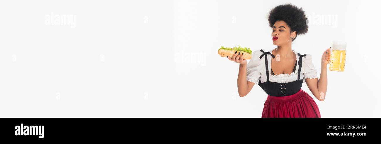 Wir waren zufrieden mit der afroamerikanischen bayerischen Kellnerin mit Becher und Hot Dog auf weißem oktoberfest, Banner Stockfoto