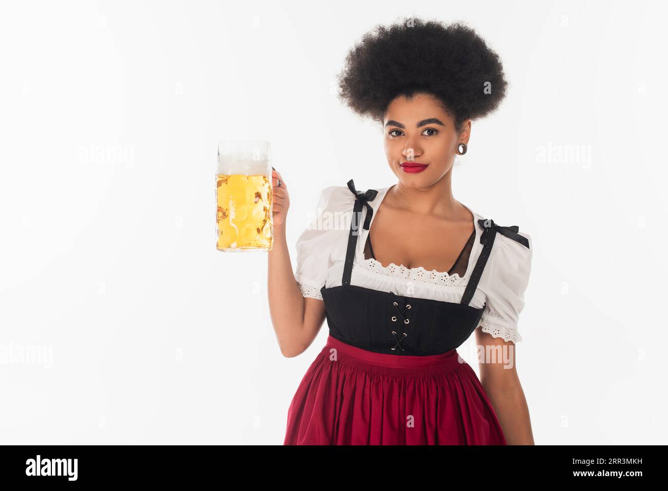 Freute afroamerikanische oktoberfest-Kellnerin in authentischem Kostüm mit Becher Craft Beer auf weiß Stockfoto