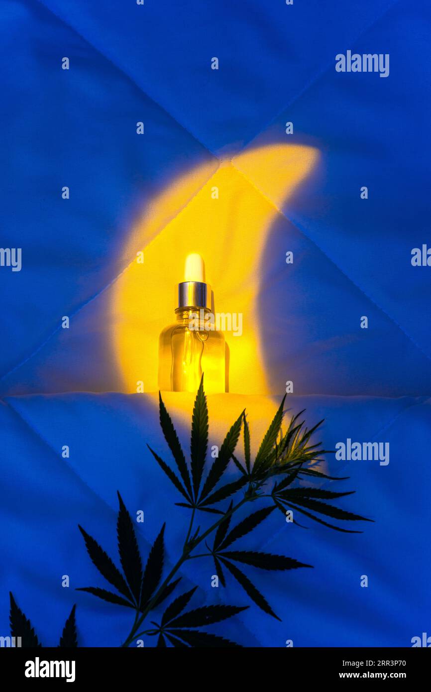 CBD-Öltinktur und Marihuana-Blatt unter den Abdeckungen zur Verbesserung des Schlafs Stockfoto