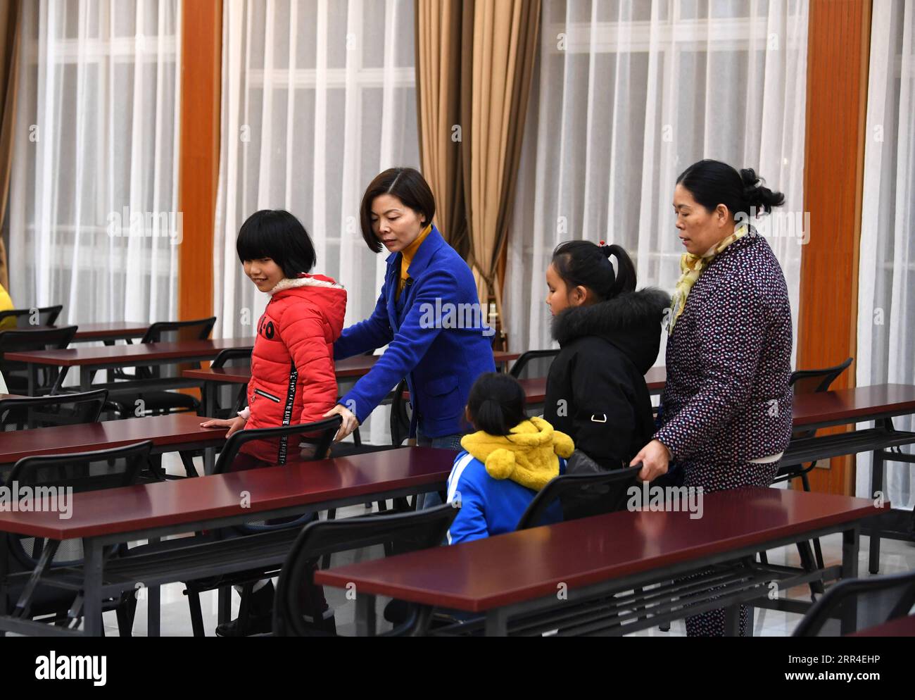 201202 -- WUHU, 2. Dez. 2020 -- Xi Weijing 2. L, Leiter der Wuhu Schule für Blinde, führt die Schüler während der Musikprobe an der Schule in Wuhu, ostchinesische Provinz Anhui, am 25. November 2020 zu ihren Sitzen. XI Weijings Eltern sind beide sehbehindert. Ihr Vater Xi Manqiao gründete 1979 eine private Schule für Blinde und widmete all seine Energie der Arbeit der Schule. Nachdem ihr Vater 1994 an Krankheit gestorben war, übernahm Xi Weijing, damals in ihren 20ern, die Last und wurde der zweite Direktor der Wuhu Schule für Blinde. Mit Unterstützung der lokalen Regierung, der Wuhu-Schule für Stockfoto