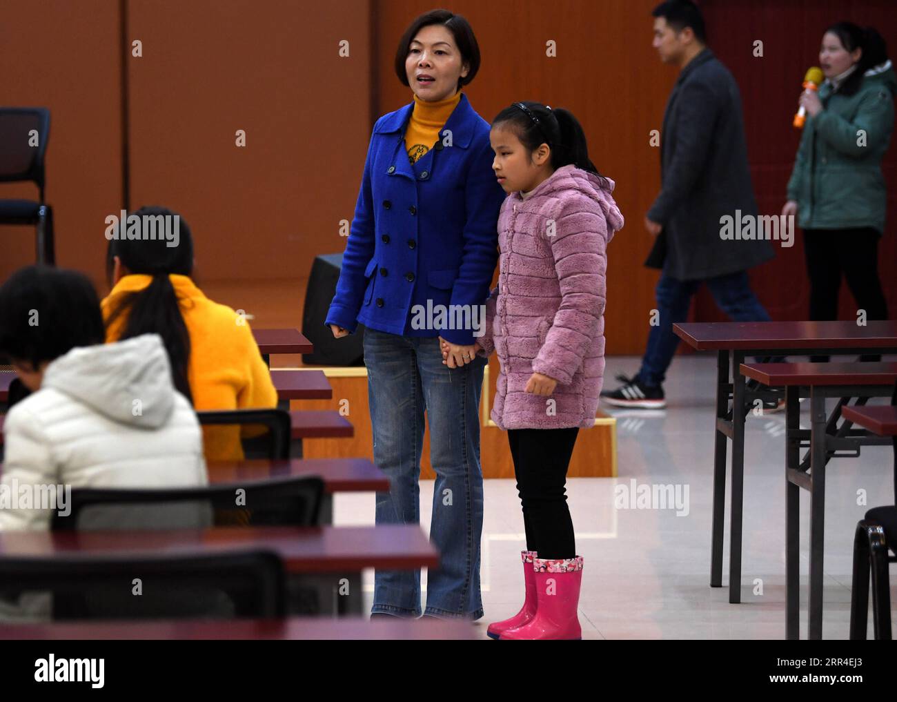 201202 -- WUHU, 2. Dezember 2020 -- Xi Weijing, Leiterin der Schule für Blinde in Wuhu, führt eine Schülerin während der Musikprobe an der Schule in Wuhu, ostchinesische Provinz Anhui, am 25. November 2020 zu ihrem Platz. XI Weijings Eltern sind beide sehbehindert. Ihr Vater Xi Manqiao gründete 1979 eine private Schule für Blinde und widmete all seine Energie der Arbeit der Schule. Nachdem ihr Vater 1994 an Krankheit gestorben war, übernahm Xi Weijing, damals in ihren 20ern, die Last und wurde der zweite Direktor der Wuhu Schule für Blinde. Mit Unterstützung der örtlichen Regierung, der Wuhu Schule für Blinde Stockfoto