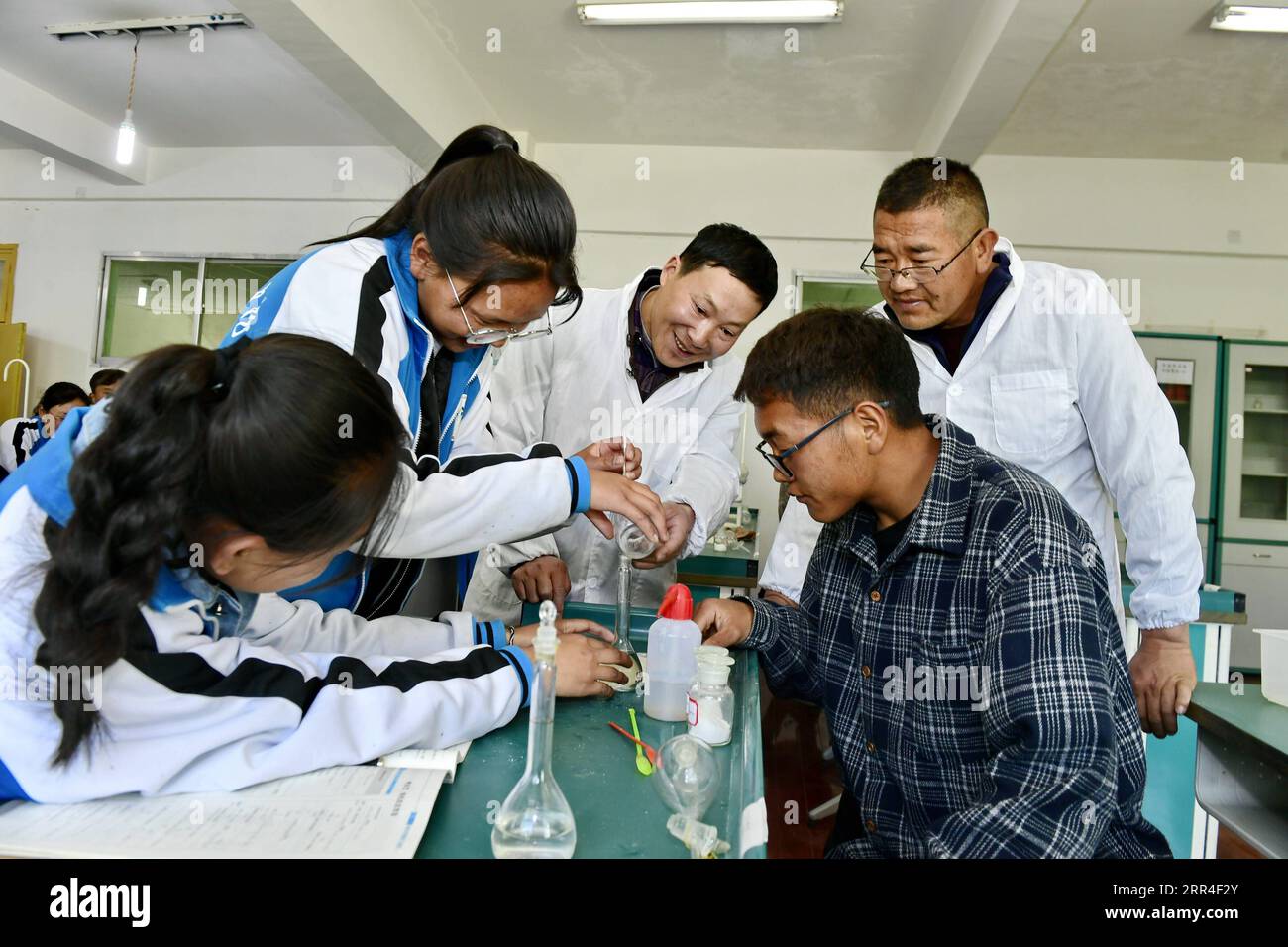 201202 -- LHASA, 2. Dezember 2020 -- Cai Chunting C, ein Lehrer aus der Stadt Xiangyang in der Provinz Hubei in Zentralchina, und Cering Choden Back R, ein lokaler Lehrer, Tutorenstudenten in einem Chemieexperiment in der Shannan No.1 Senior High School, der autonomen Region Tibet im Südwesten Chinas, 7. Mai 2019. Die chinesische Regierung hat bisher mehr als 20 Milliarden Yuan für die Unterstützung des kostenlosen Bildungsprogramms der Region ausgegeben, wodurch Bildung für fast neun Millionen Studenten zugänglicher wird. Studierende aller Klassen können auch über eine Reihe von Projekten und Initiativen im Rahmen von 40 Bildung auf zusätzliche Unterstützung zugreifen Stockfoto