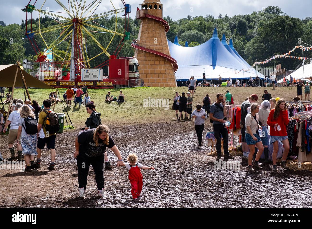Ein kleines Kleinkind versucht beim Green man Festival, Brecon, Wales, Großbritannien, 2023, den Schlamm zu überqueren. Foto: Rob Watkins Stockfoto