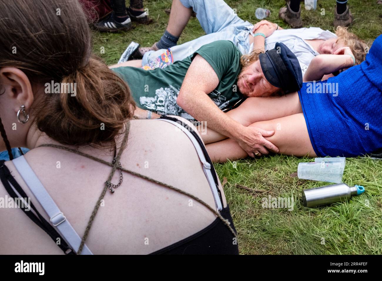 Ein Mann macht ein Nickerchen auf dem Schoß seiner Partnerin, Festivalbesucher mittleren Alters beim Green man Festival, Brecon, Wales, Großbritannien, 2023. Foto: Rob Watkins Stockfoto