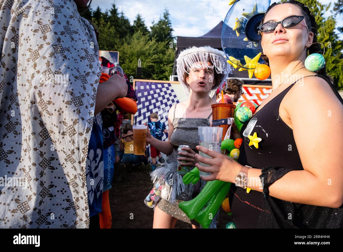 Eine Gruppe bunt gekleideter Frauen mit Bierkuchen beim Green man Festival, Brecon, Wales, Großbritannien, 2023. Foto: Rob Watkins Stockfoto