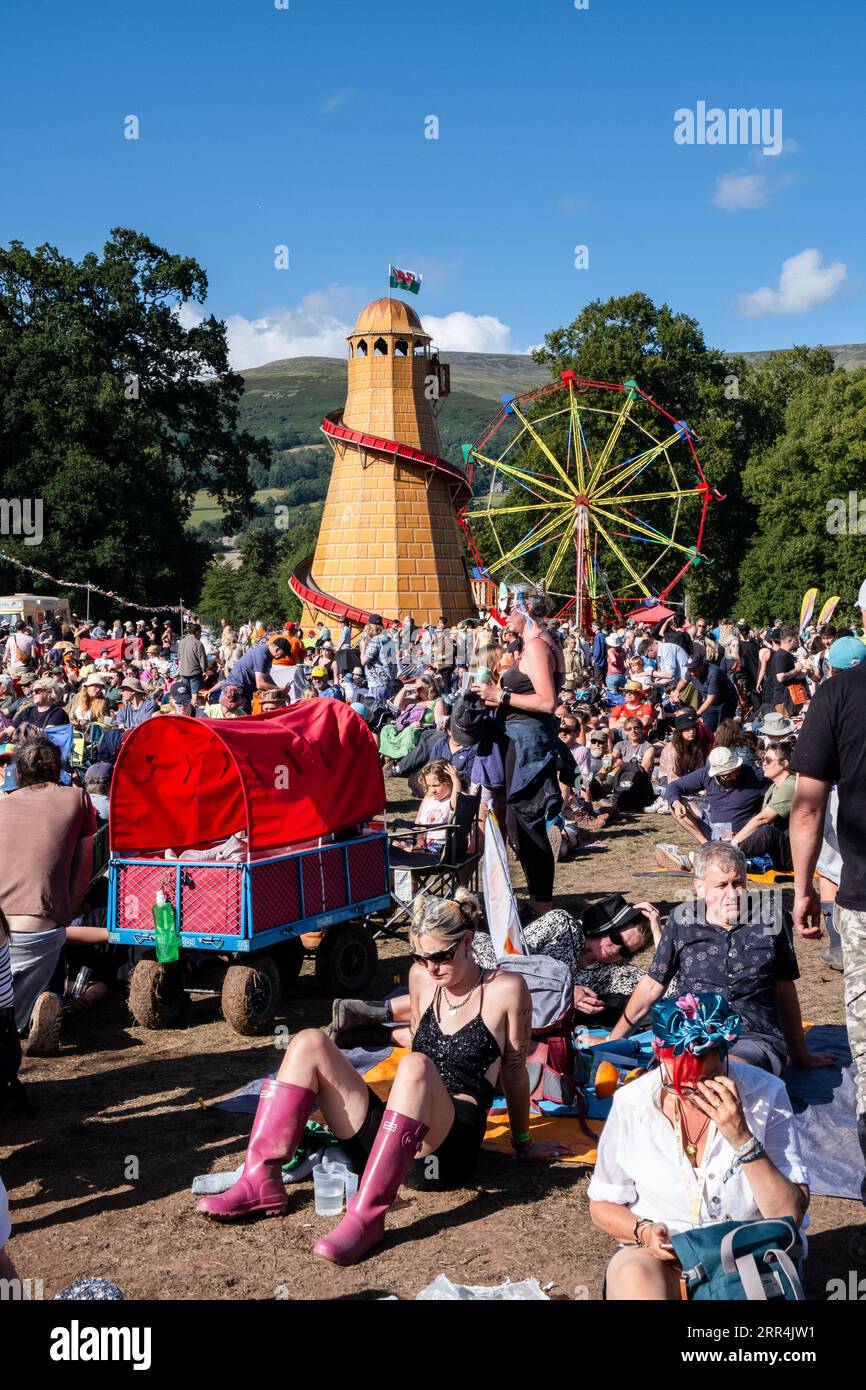 Die Leute sitzen im Schlamm bei Sonnenschein im Barbereich vor der Far Out Stage beim Green man Festival, Brecon, Wales, Großbritannien, 2023. Foto: Rob Watkins Stockfoto