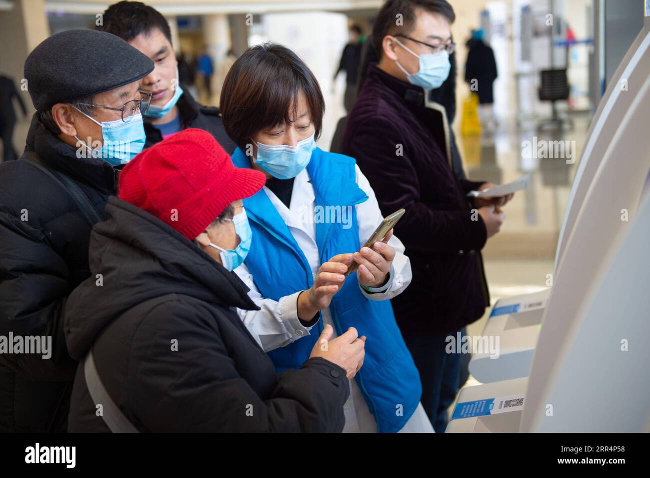 201210 -- PEKING, 10. Dezember 2020 -- Ein Mitarbeiter hilft Senioren, die Krankenhausrechnungen im Beijing Tiantan Hospital unter der Capital Medical University in Peking, Hauptstadt von China, am 9. Dezember 2020 per Handy zu bezahlen. China hat eine dreijährige Kampagne gestartet, um den Senioren des Landes dabei zu helfen, die digitale Kluft zu überwinden und die Entwicklung intelligenter Technologien zu genießen. Die Regierung hat vor kurzem einen Plan mit Maßnahmen vorgelegt, die älteren Menschen dabei helfen sollen, Hindernisse für die Nutzung intelligenter Technologien zu überwinden und gleichzeitig die traditionellen Dienste für sie aufrechtzuerhalten. Der Plan, der vom Generalbüro der St. Stockfoto