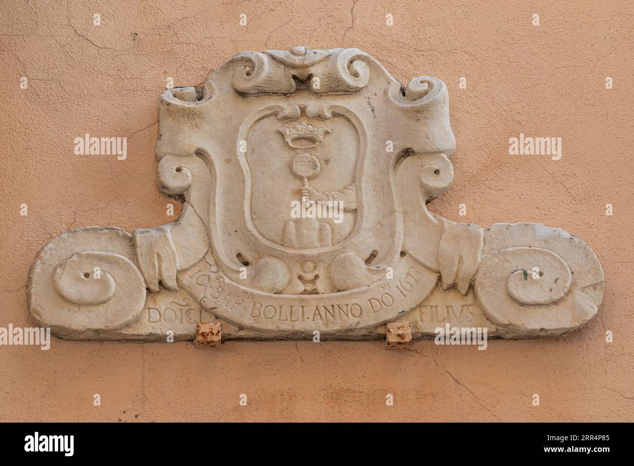 Marmorplakette mit Wappen und lateinischer Inschrift aus dem Jahr 1673 an einer Mauer in der Altstadt Albissola Superiore, Savona, Ligurien, Italien Stockfoto