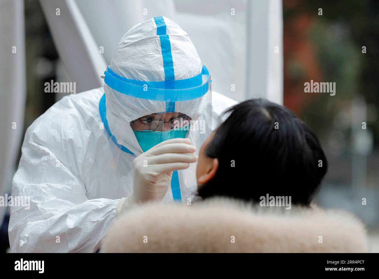 201211 -- PEKING, 11. Dezember 2020 -- Ein Angestellter des medizinischen Personals holt eine Abstrichprobe von einem Bewohner für COVID-19-Test am Pidu District Hospital of Traditional Chinese Medicine in Pidu District of Chengdu, Hauptstadt der südwestchinesischen Provinz Sichuan, 10. Dezember 2020. XINHUA FOTOS DES TAGES ShenxBohan PUBLICATIONxNOTxINxCHN Stockfoto