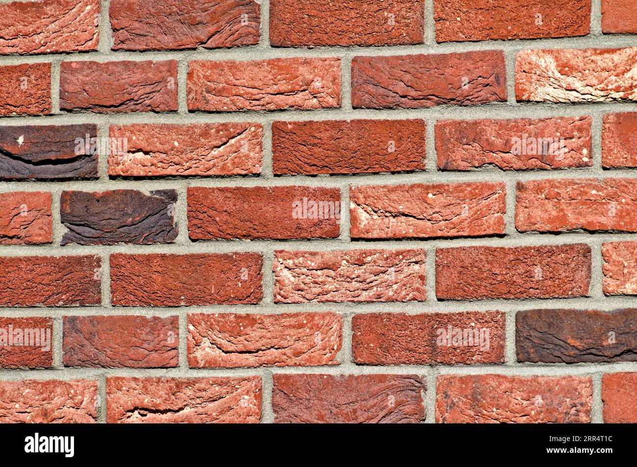 Abstraktes Hintergrundfoto einer Wand aus orangen Ziegeln. Schöne Kunststoffverkleidung am Gebäude. Kann als Musterhintergrund verwendet werden. Stockfoto