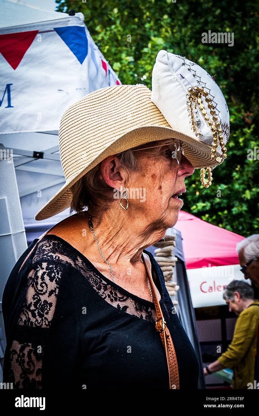 Bridport, Dorset. England. Die Leute feiern das Bridport hat Festival mit phantasievoller Kopfbedeckung. Ein Handtaschenhut. Stockfoto