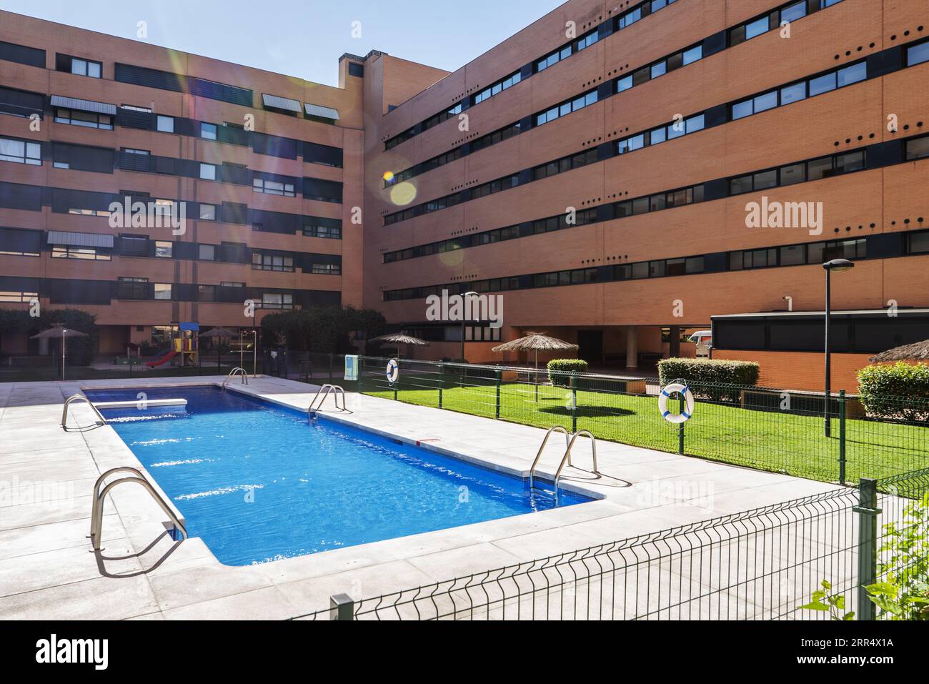 Gemeinschaftliches Sommerbad in den Gemeinschaftsbereichen mit Gärten und Rasenflächen eines Wohnkomplexes mit urbanem Wohngebiet Stockfoto