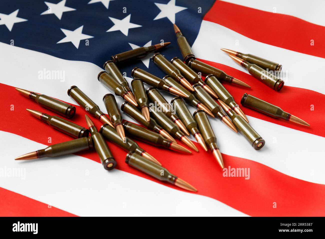 Kugeln für Schusswaffen, Kampfarmeekartuschen auf der amerikanischen Flagge. Das Konzept der Verleihvermietung, der Lieferung von Waffen, der Unterstützung, des Waffenverkaufs. Stockfoto