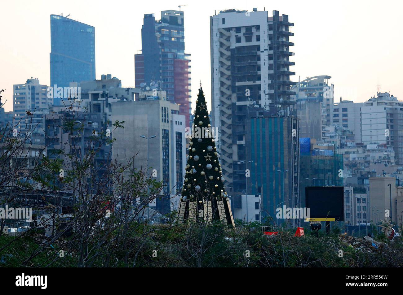 201223 -- BEIRUT, 23. Dez. 2020 -- Ein Weihnachtsbaum mit Namen derer, die während der Explosion des Beiruter Hafens gestorben sind, wird in der Nähe eines beschädigten Getreidesilo in Beirut, Libanon, am 22. Dez. 2020 gesehen. Zwei riesige Explosionen erschütterten am 4. August den Hafen von Beirut, wobei mindestens 190 Menschen getötet wurden, während rund 6.000 weitere verletzt wurden und 300.000 Menschen obdachlos wurden. Foto von /Xinhua LEBANON-BEIRUT-CHRISTMAS TREE-MEMORY OF EXPLOSION VICTIMS BilalxJawich PUBLICATIONxNOTxINxCHN Stockfoto