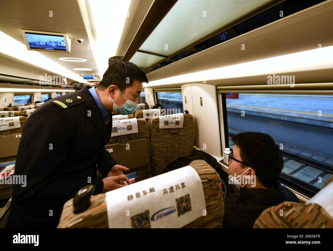 201224 -- CHENGDU, 24. Dezember 2020 -- Ein Mitarbeiter erklärt die Mitteilung, am 24. Dezember 2020 mit dem Hochgeschwindigkeitszug G8609 vom Ostbahnhof Chengdu in der südwestchinesischen Provinz Sichuan zum Bahnhof Shapingba im südwestchinesischen Chongqing Ein ruhiges Auto zu nehmen. Einige Hochgeschwindigkeitszüge in China haben leise Autos für Passagiere, die sich für ein ruhiges und ungestörtes Reiseerlebnis entscheiden. Das leise Auto ist oft die Kutsche Nr. 3 im Zug, mit Videos an Bord stummgeschaltet und Durchsagen mit einer geringeren Lautstärke gemacht. Die Türen an den Enden des Schlittens werden geschlossen, um Geräusche von zu reduzieren Stockfoto