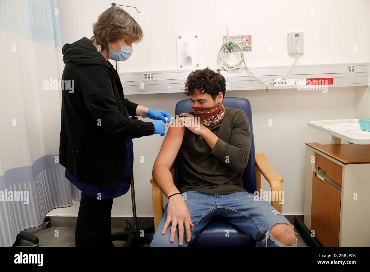 201229 -- RAMAT GAN, 29. Dezember 2020 -- Ein Freiwilliger erhält den von Israel entwickelten Anti-Coronavirus-Impfstoff im Sheba Medical Center in der zentralisraelischen Stadt Ramat Gan, 28. Dezember 2020. Die zweite Phase der klinischen Studie für den COVID-19-Impfstoffkandidaten, die vom staatlichen Institut für biologische Forschung Israels entwickelt wurde, wurde am Montag durchgeführt. Foto von /Xinhua ISRAEL-RAMAT GAN-COVID-19-VACCINE GilxCohenxMagen PUBLICATIONxNOTxINxCHN Stockfoto