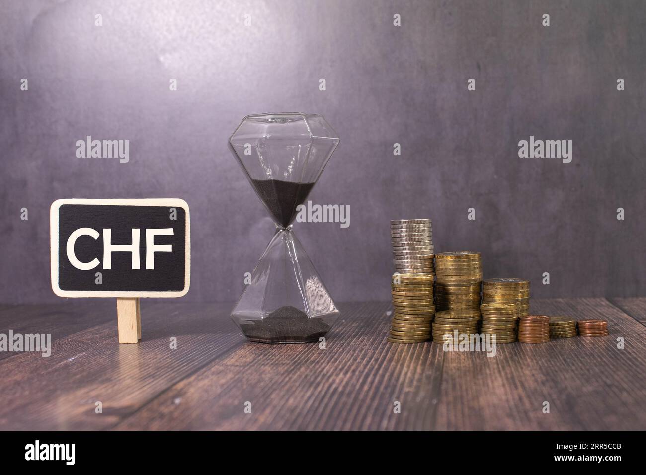 Die ISO-Code-Währung CHF erscheint aus dem Sand und bröckelt dann. Alphakanal vormultipliziert – mit schwarzer Farbe verfilzt Stockfoto