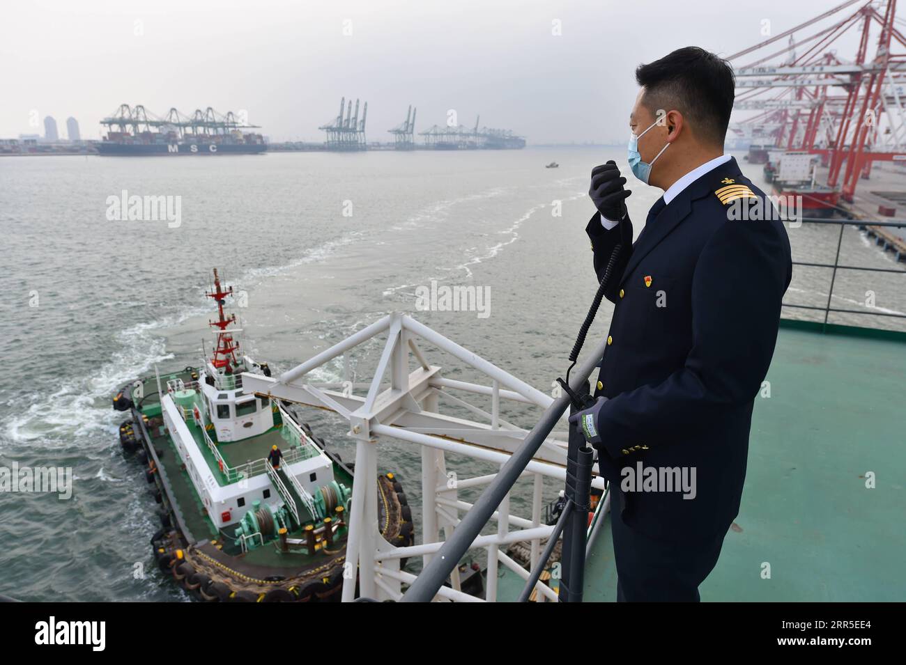 210103 -- TIANJIN, 3. Januar 2021 -- Li Zhantao, ein Pilot des Tianjin Port Pilot Center, leitet ein Schlepper, um einem Schiff zu helfen, vom Dock im nordchinesischen Tianjin abzufahren, 28. Dezember 2020. Mit einer Temperatur von minus 10 Grad Celsius klettern die Piloten auf Seilleitern von fast 20 Metern Länge, um das Deck der Schiffe zu erreichen, die sie durch Gewässer im und um den Hafen von Tianjin führen sollen. Die chinesischen Gesetze schreiben die obligatorische Pilotierung von ausländischen Schiffen vor, die in Häfen des Landes einlaufen oder aus ihnen auslaufen. Lotsendienste sind auch ein praktischer Bedarf für ausländische Schiffe im Hafen von Tianjin, der für seine vielbeschäftigten an bekannt ist Stockfoto