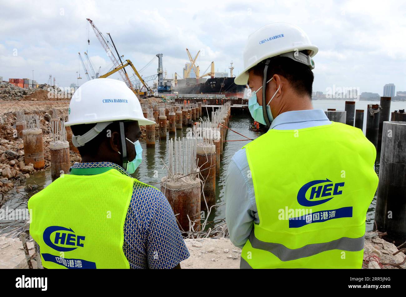 210109 -- NAIROBI, 9. Januar 2021 -- Ingenieure aus China und Tansania sprechen über den Bauplan auf der Baustelle des Projekts zur Modernisierung des Hafens dar es Salaam in dar es Salaam, Tansania, 8. Juli 2020. Schlagzeilen: Chinese FM schließt Besuch in fünf afrikanischen Ländern mit fruchtbaren Ergebnissen ab, erneuertes Vertrauen Xinhua PUBLICATIONxNOTxINxCHN Stockfoto