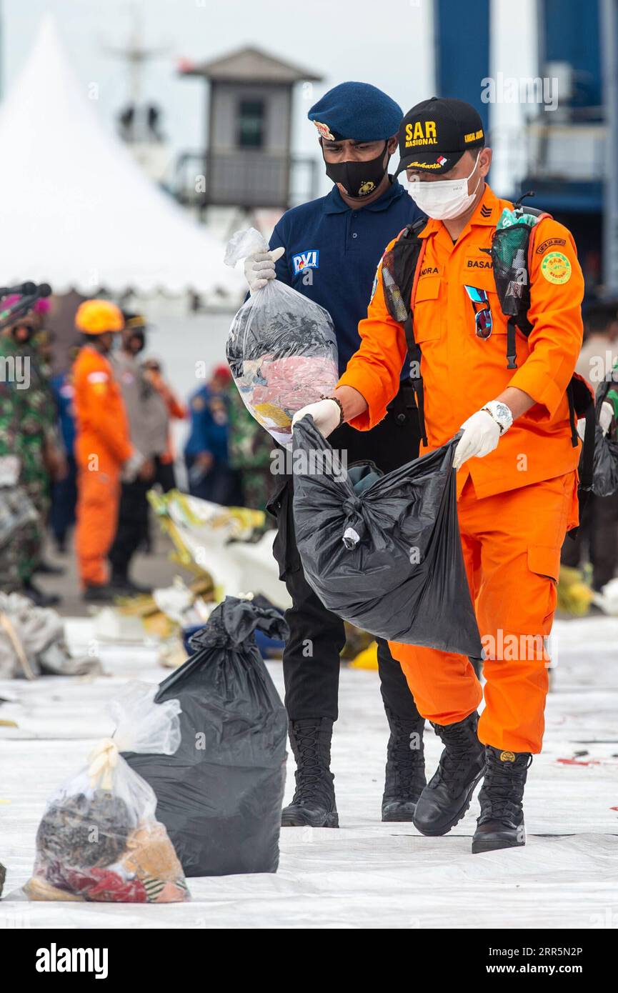 210111 -- JAKARTA, 11. Januar 2021 -- Offiziere des indonesischen Such- und Rettungs-SAR-Teams transportieren Passagiere mit dem Gepäck des Flugzeugs Sriwijaya Air am 11. Januar im SAR-Kommandozentrum Tanjung Priok, Jakarta, Indonesien, 2021. das Such- und Rettungsteam Indonesiens hat das Einsatzgebiet erweitert, um nach Trümmern und Opfern des Flugzeugabsturzes Sriwijaya mit mehr Flotten am dritten Einsatztag zu suchen, teilte die indonesische nationale Such- und Rettungsagentur am Montag mit. Bis jetzt haben die Offiziere die Trümmer des unglückseligen Flugzeugs und Leichenteile, die Eigentum der Opfer sind, gefunden und den Ort geschätzt Stockfoto