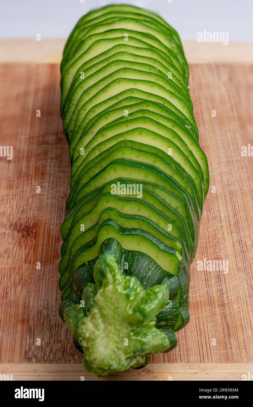 Zucchini in Scheiben auf Bambusschneidebrett. Studio-Aufnahme. Stockfoto