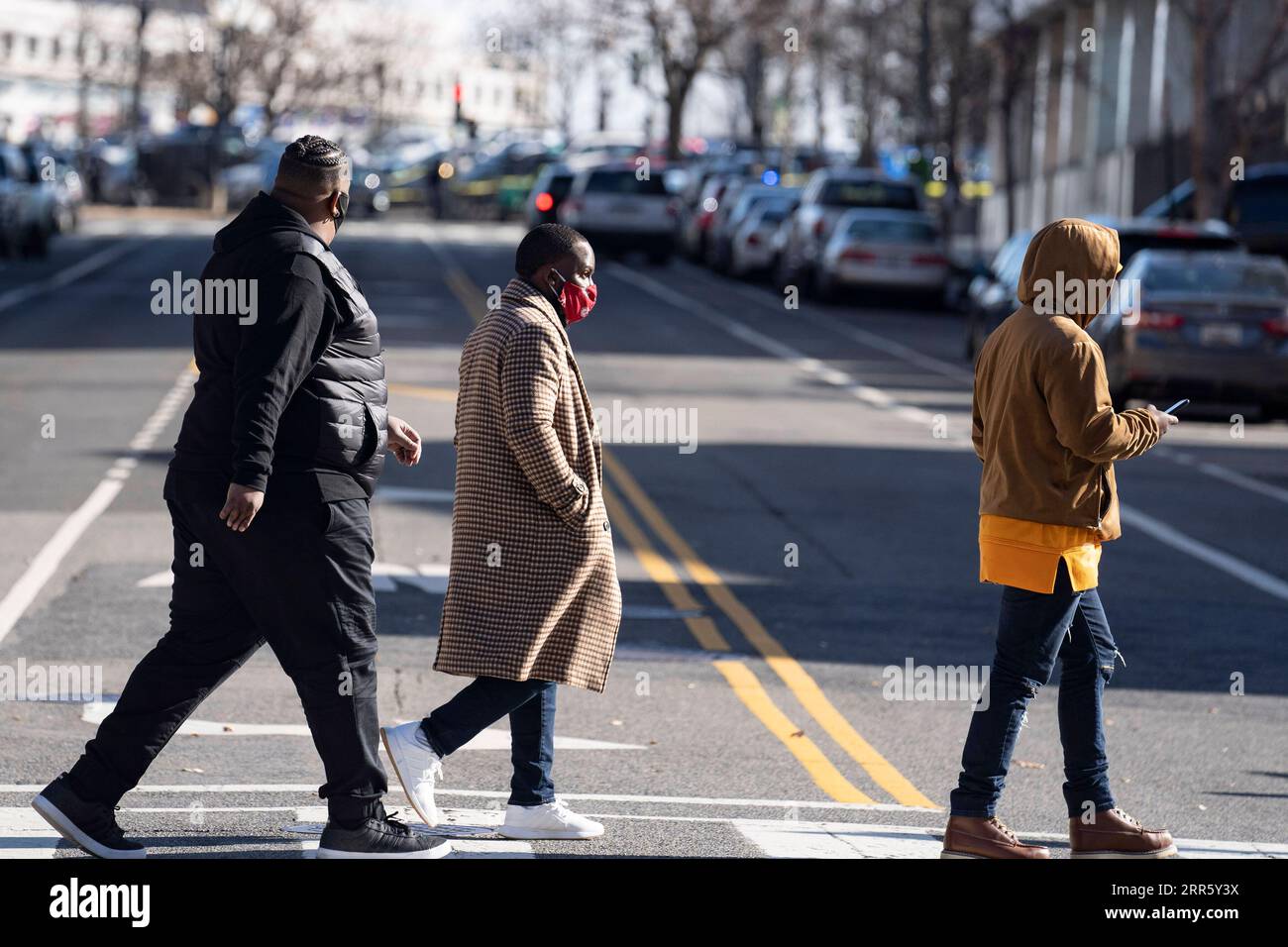 210118 -- WASHINGTON, 18. Januar 2021 -- Menschen, die Gesichtsmasken tragen, überqueren am 18. Januar 2021 eine Straße in der Nähe des Kapitolgebäudes in Washington, D.C., USA. Die Gesamtzahl der COVID-19-Fälle in den Vereinigten Staaten betrug am Montag mehr als 24 Millionen, so das Center for Systems Science and Engineering CSSE an der Johns Hopkins University. Die Zahl der COVID-19-Fälle in den USA stieg auf 24.018.793 mit insgesamt 398.307 Todesfällen (Stand 14:21 Uhr Ortszeit 1921 GMT), laut CSSE-Tabelle. U.S.-WASHINGTON, D.C.-COVID-19-CASES-24 MILLION LIUXJIE PUBLICATIONXNOTXINXCHN Stockfoto