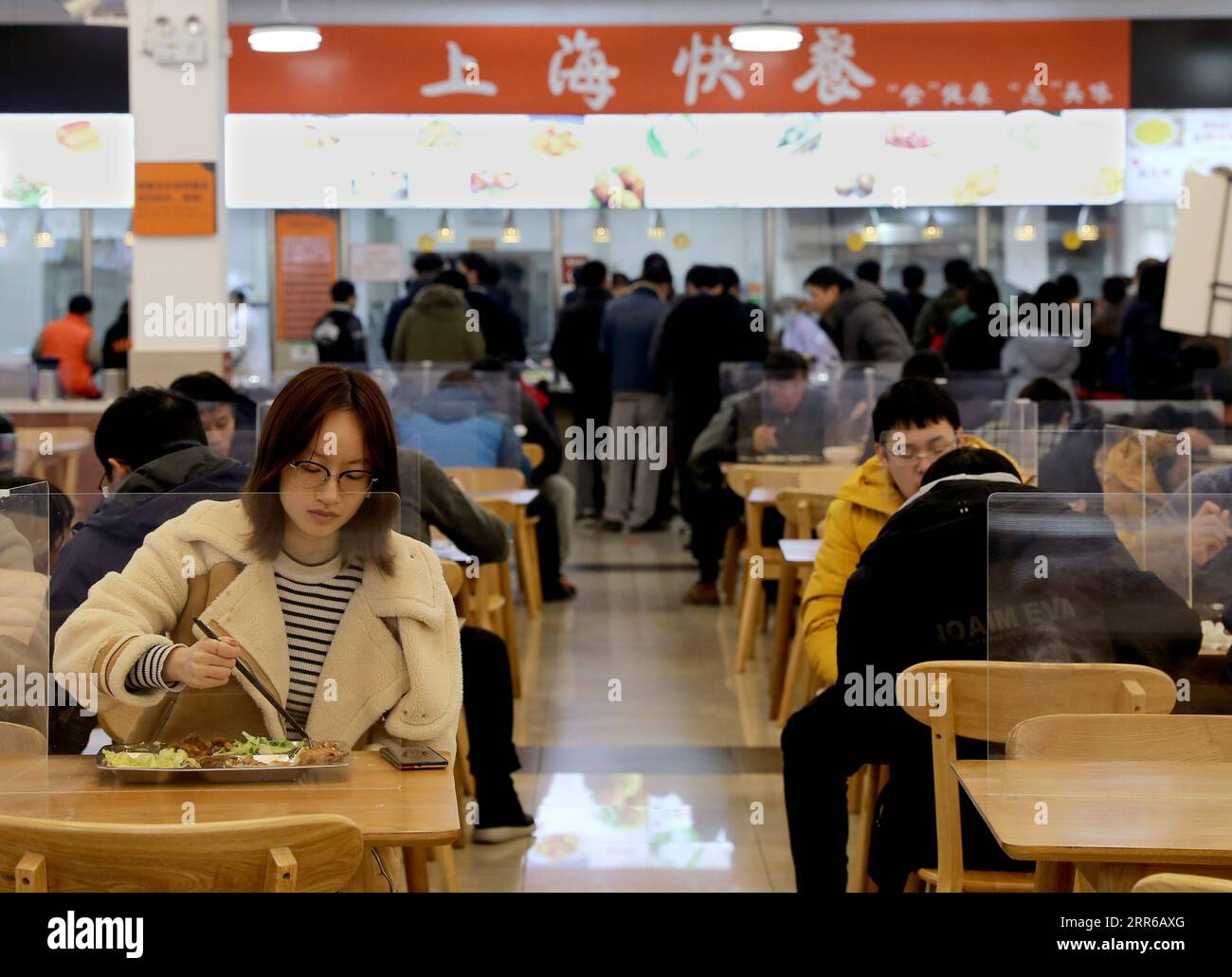 210203 -- SHANGHAI, 3. Februar 2021 -- Lehrer und Studenten essen in einer Kantine der Shanghai Jiao Tong Universität, ostchinesische Gemeinde Shanghai, 2. Februar 2021. Etwa 2.000 Studenten der Shanghai Jiao Tong University entschieden sich, während dieses Winterurlaubs auf dem Campus zu bleiben, fast das Zehnfache der Vorjahre, und die meisten von ihnen sind Postgraduierte. Einige Studenten würden nicht nach Hause zurückkehren, weil ihre Heimatstadt in Gebieten mit mittlerem und hohem COVID-19-Infektionsrisiko liegt, und andere entschieden sich, aus Forschungs- und akademischen Erwägungen zu bleiben. Während der Ferien, die Labore und Bibliotheken Stockfoto