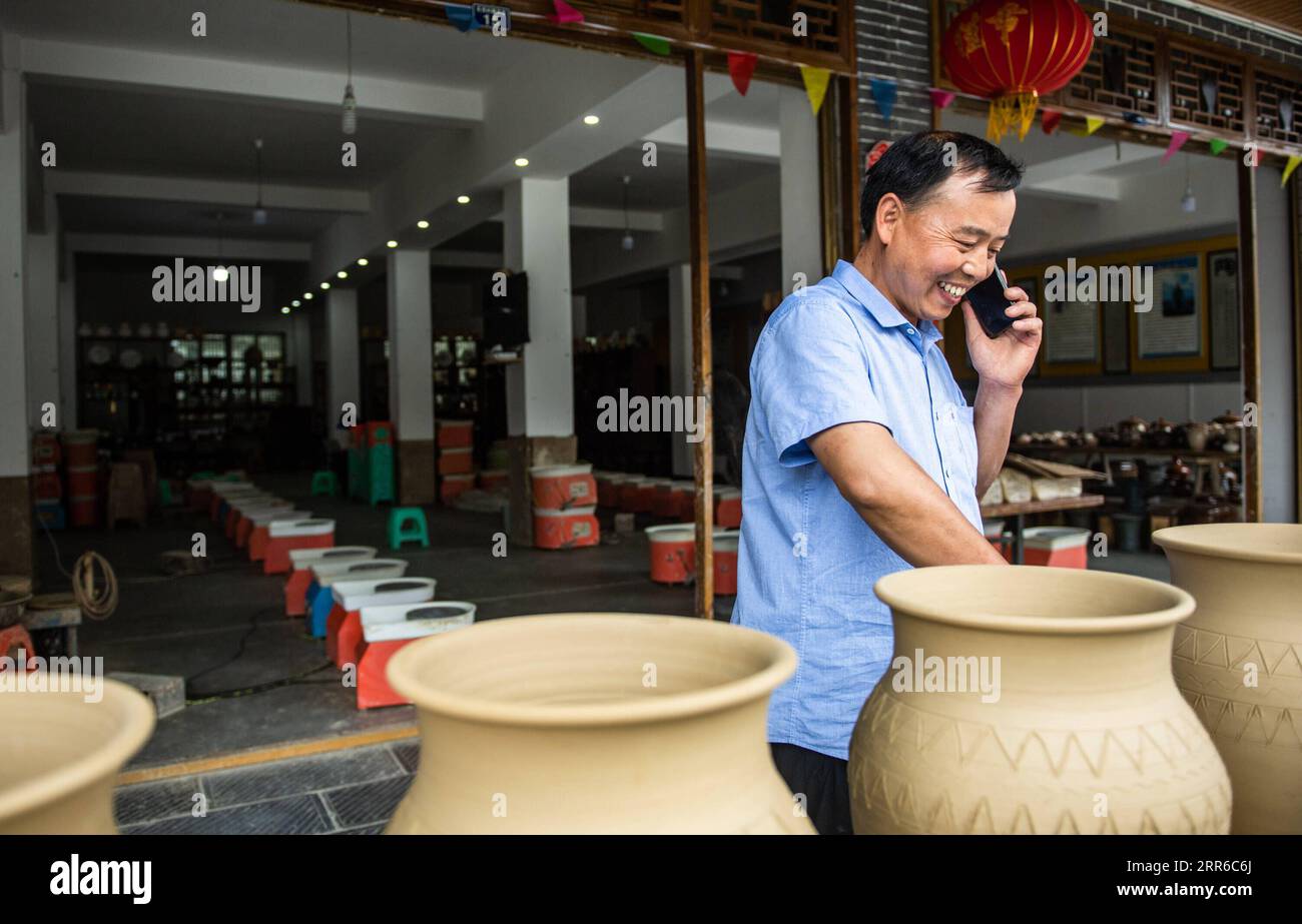 210205 -- GUIYANG, 5. Februar 2021 -- Mu Xiancai nimmt die Bestellung per Telefon von einem seiner Kunden im Dorf Huamao, Bezirk Bozhou, Zunyi Stadt der südwestchinesischen Provinz Guizhou, am 16. Juni 2020 entgegen. Guizhou, eine Region auf Provinzebene mit der größten Bevölkerung armer Menschen, hat seit 2012 mehr als 9 Millionen Menschen aus der Armut befreit. CHINA-GUIZHOU-ARMUTSBEKÄMPFUNG-LÄCHELN CN TAOXLIANG PUBLICATIONXNOTXINXCHN Stockfoto