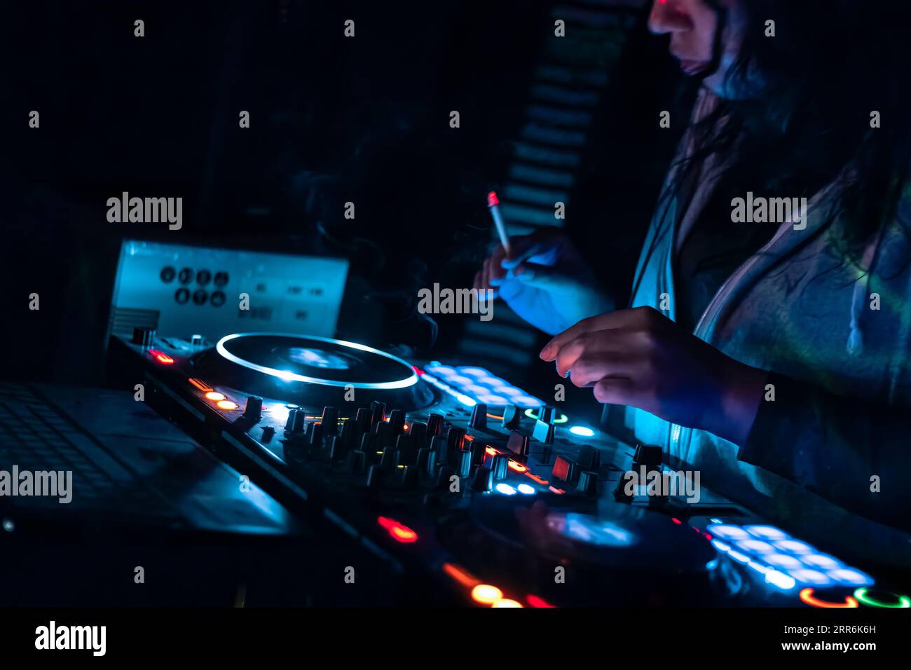 Nahaufnahme der DJ-Hände, die auf der DJ-Mischkonsole auf der Nachtclub-Party verschiedene Track-Bedienelemente spielen. Stockfoto