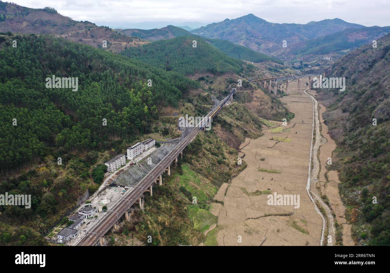 210228 -- BAISE, 28. Februar 2021 -- Luftbild zeigt einen Zug, der sich dem Bahnhof Banqi entlang der Nanning-Kunming-Bahn nähert, 26. Februar 2021. CHINA-NANNING-KUNMING EISENBAHNLANDSCHAFT CN ZHANGXAILIN PUBLICATIONXNOTXINXCHN Stockfoto