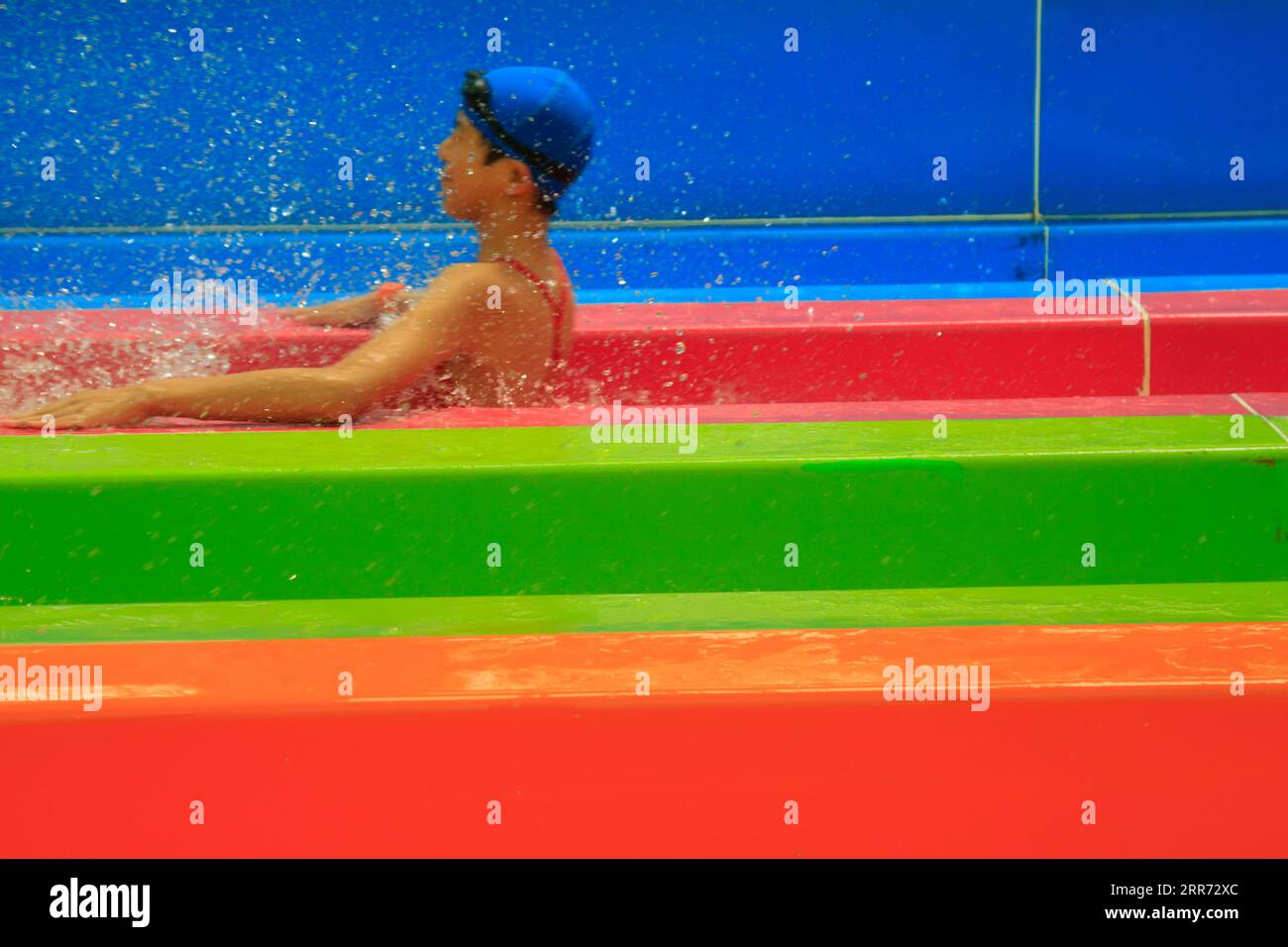 Rainbow rennt die unscharfe Figur auf der Rutsche hinunter Stockfoto