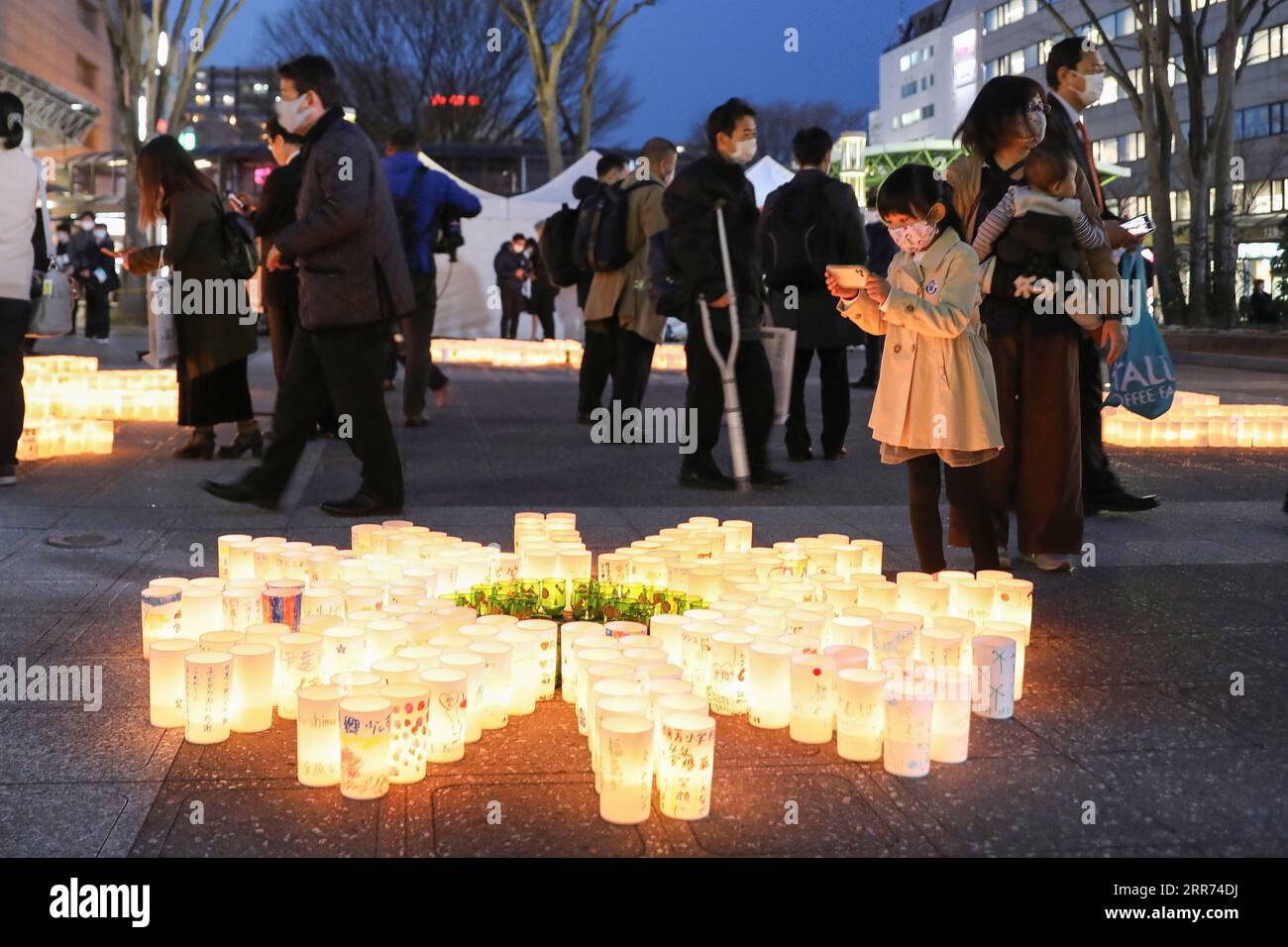 210311 -- TOKIO, 11. März 2021 -- Ein Mädchen macht Fotos von Papierlaternen mit Eulogen, um der Opfer des großen Erdbeben- und Tsunamis in Tokio, Japan am 11. März 2021 zu gedenken. JAPAN-BEBEN-TSUNAMI-JUBILÄUM DuxXiaoyi PUBLICATIONxNOTxINxCHN Stockfoto